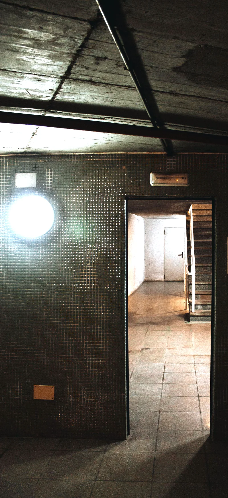 The tiled service doorway at the back of the building, with the stair beyond.