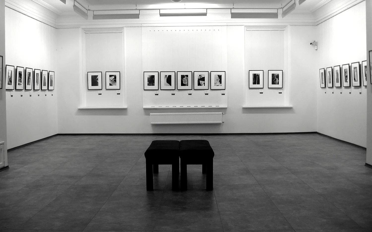 A long gallery room hung on one line, with a single bench in the middle of the floor.